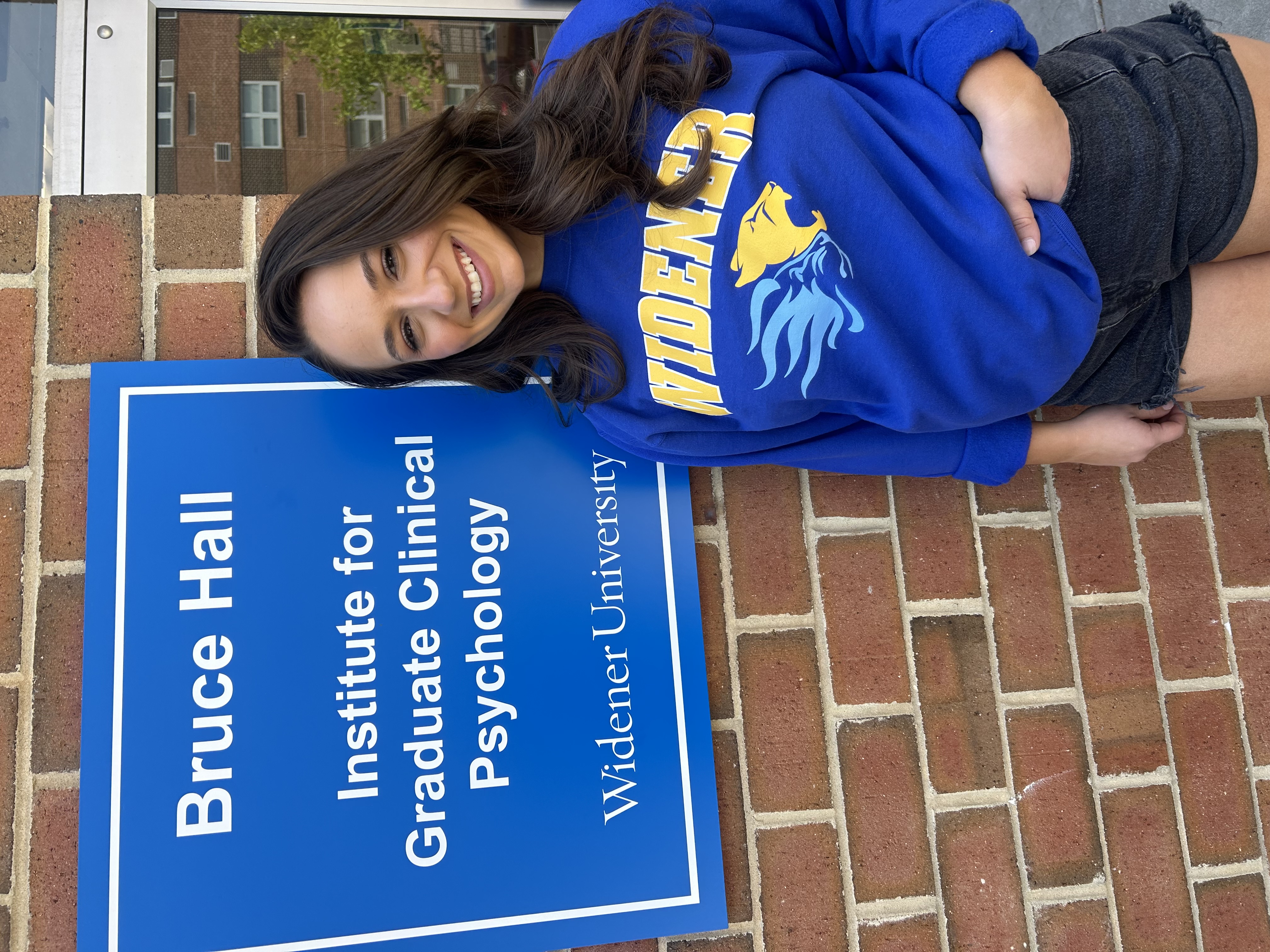 Belle Nicholas poses in front of Bruce Hall, home of the Institute for Graduate Clinic Psychology.