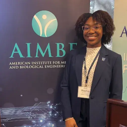 Shaylyn Westmoreland smiles for a photo at an industry research conference.