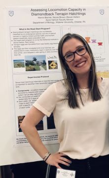 Hanna Banner poses in front of a research poster.