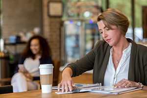 Adult student studying in coffee shop with bunder