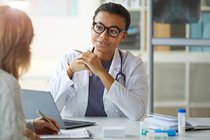 Advanced clinical nurse speaking to patient in hospital setting