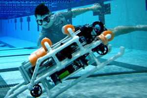 Student with robosubmarine in pool