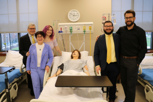 Marietta and Mike Borinski (left) pose with their family and a sim mannequin at the lab's dedication event.