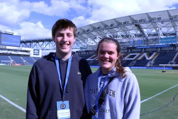 Chris Coughlin and Grace Kelly pose for a photo on the field at Subaru Park