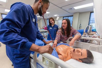 Nursing students practice their skills on a mannequin.