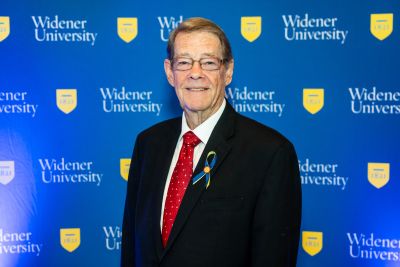 Charles Chuck Cantley Jr stands in front of a blue Widener backdrop