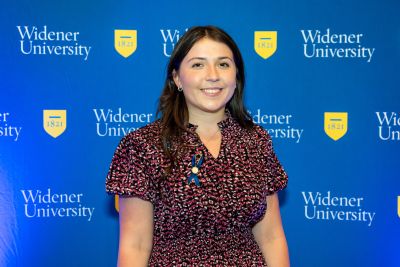 Lauren McCarthy stands in front of a blue Widener backdrop
