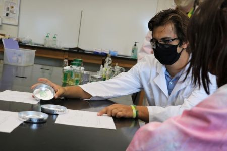 Student wearing mask tests detergents in lab