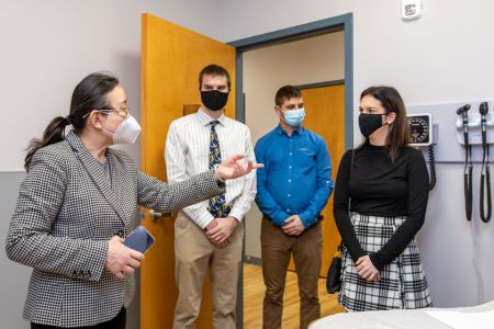 Doctor talks to three students in medical facility