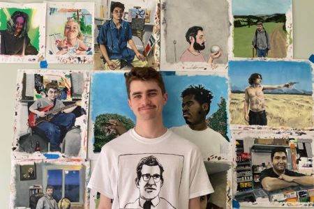 Kevin stands in front of his art