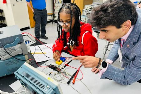 Ali Hamza works with a female student with technology in the lab.