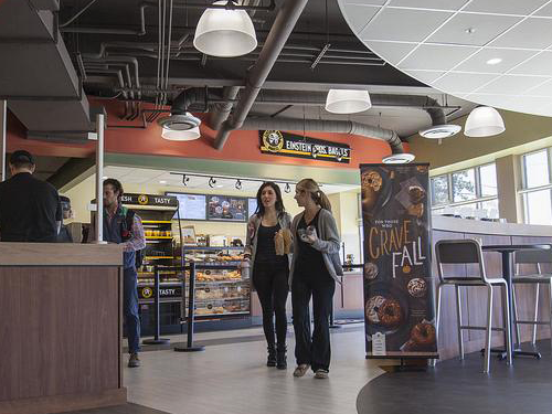 Adult students eating at Einstein Bros. Bagels