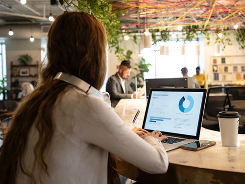Economics student on laptop working in trendy co-working space