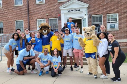 Move in day 2025 students mascots 960x640 Student volunteers pose on the steps of Cann Hall with the mascots welcoming new students to campus.