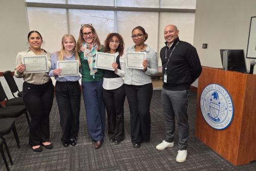 Four SBA students, a faculty member and a CO-OP supervisor standing together, posed during Honors Week