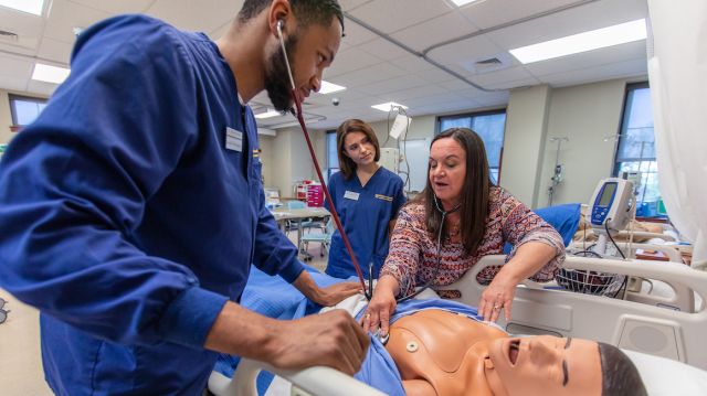 bachelor's degree in nursing BSN students work with faculty member in simulation lab. Learn more about earning your BSN degree.
